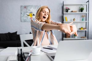 Femme fatiguée devant son agenda et son ordinateur au moment de la rentrée